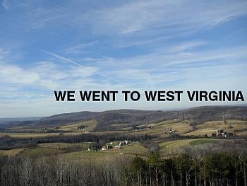 A picture of a valley with farmhouses with the words "We went to West Virginia" hanging in the sky.