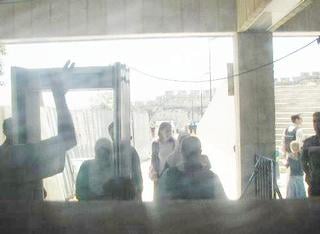 Palestinian women delayed at a security checkpoint before they can walk to the Al Aqsa mosque or the Dome of the Rock. 'Take a picture, it's racism', said my friend. Shy and afraid, I shot this through a piece of glass. My steel-toed shoes set off the metal detector and I had to remove them and hand them to the guard.