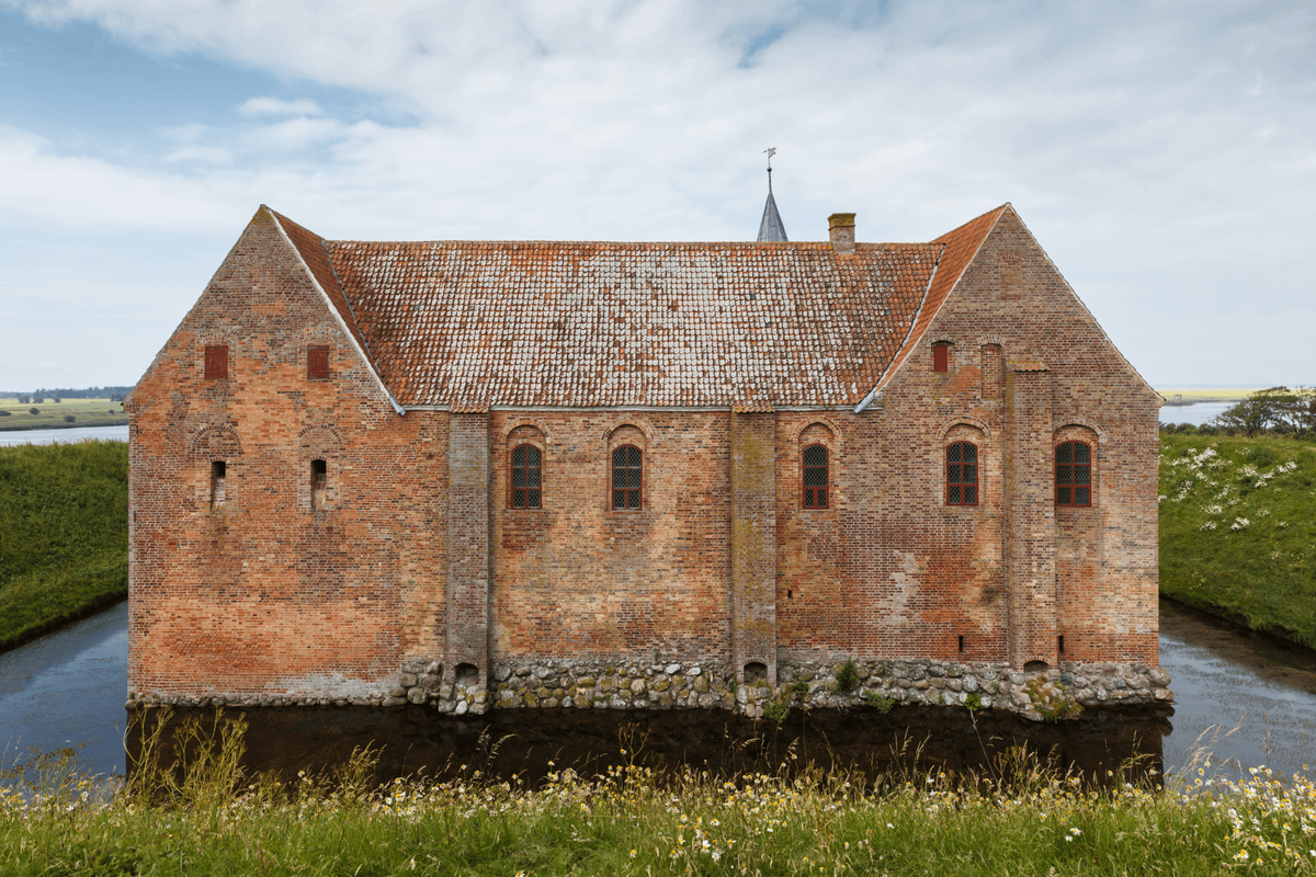 Image of an old house surrounded by a moat.