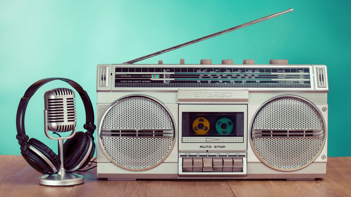 Photograph of a boom box, old-style microphone, and headphones