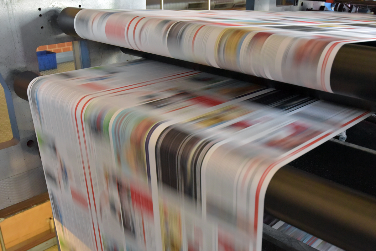 Image of newspapers being printed.