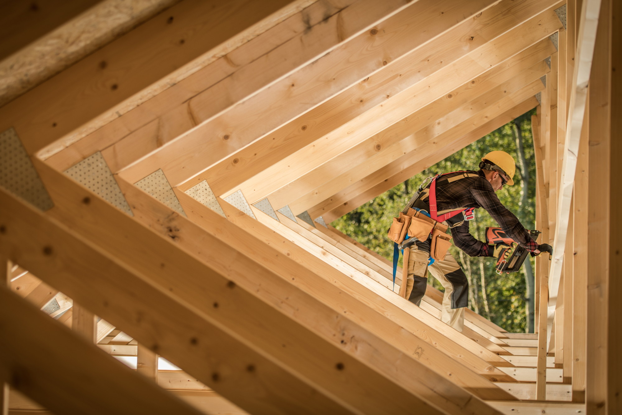 Image of a construction worker framed by a series of wooden triangles.