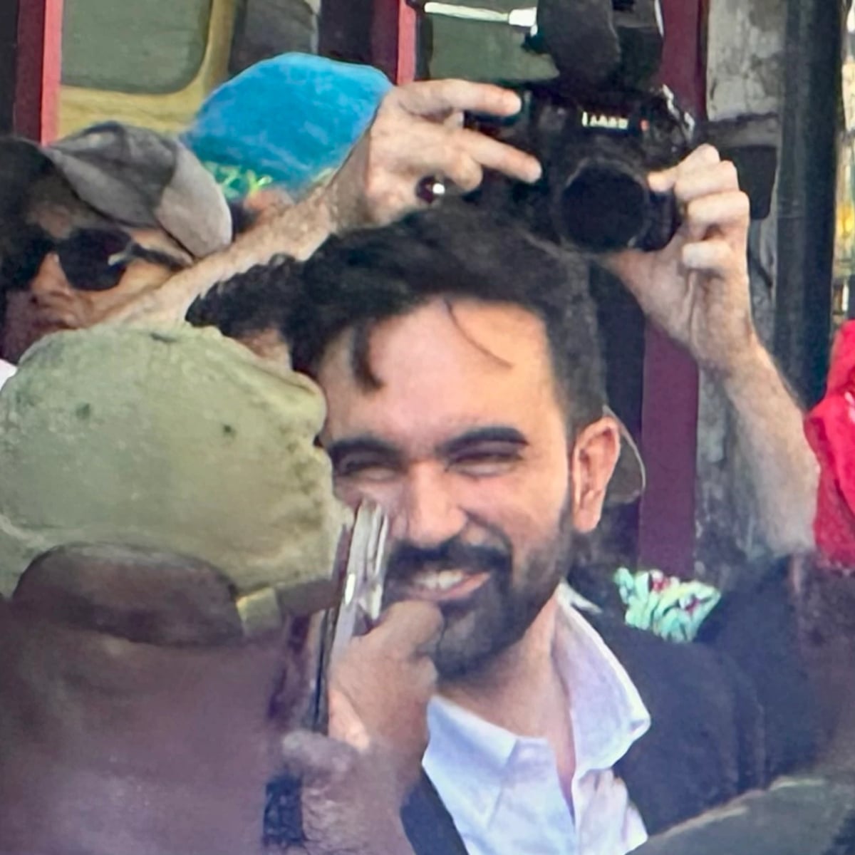 Zohran Momdani surrounded by well wishers and cameras in Brooklyn. 