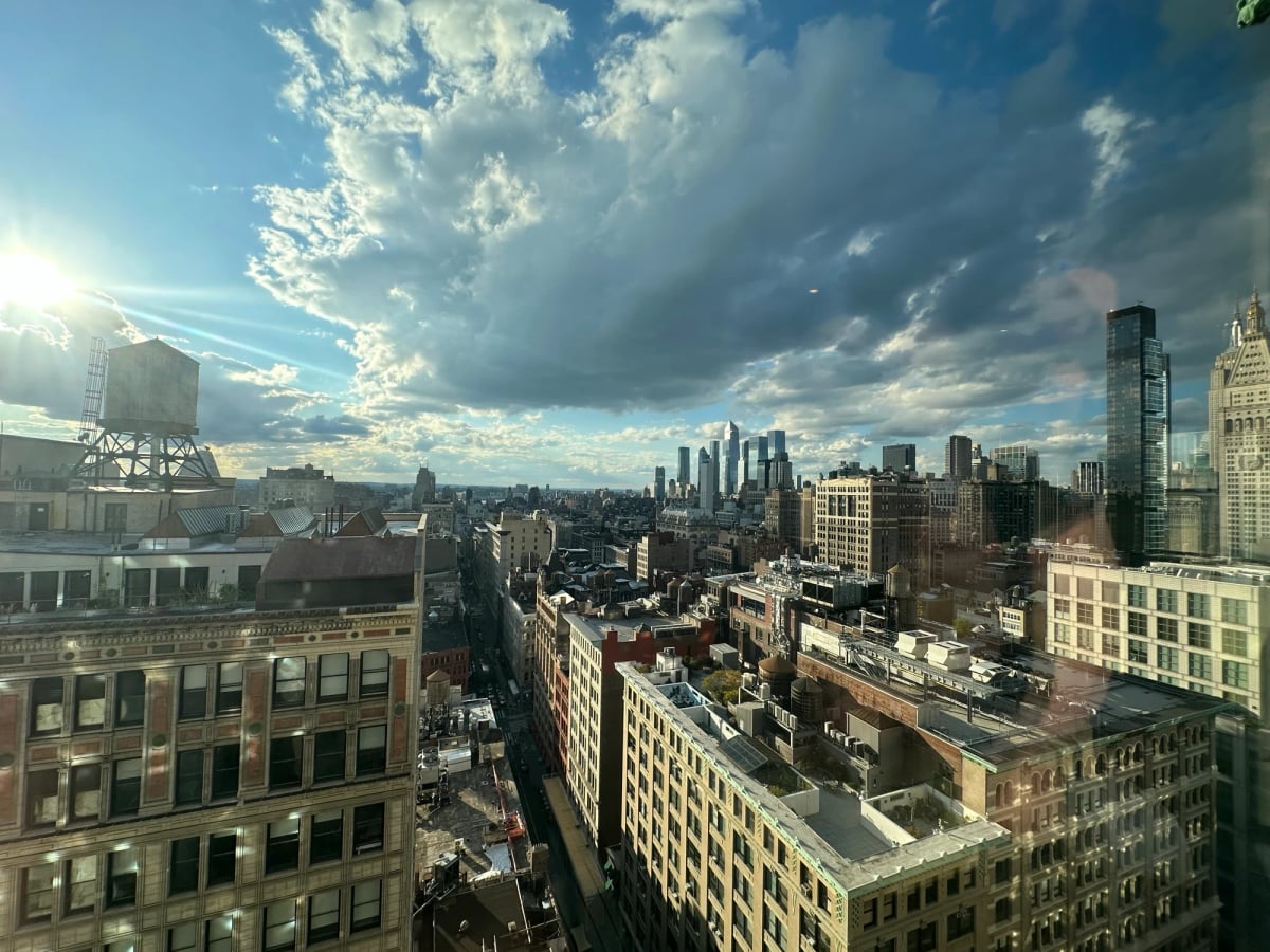 New York with clouds and tall building with sun at some sort of apex of urban beauty.
