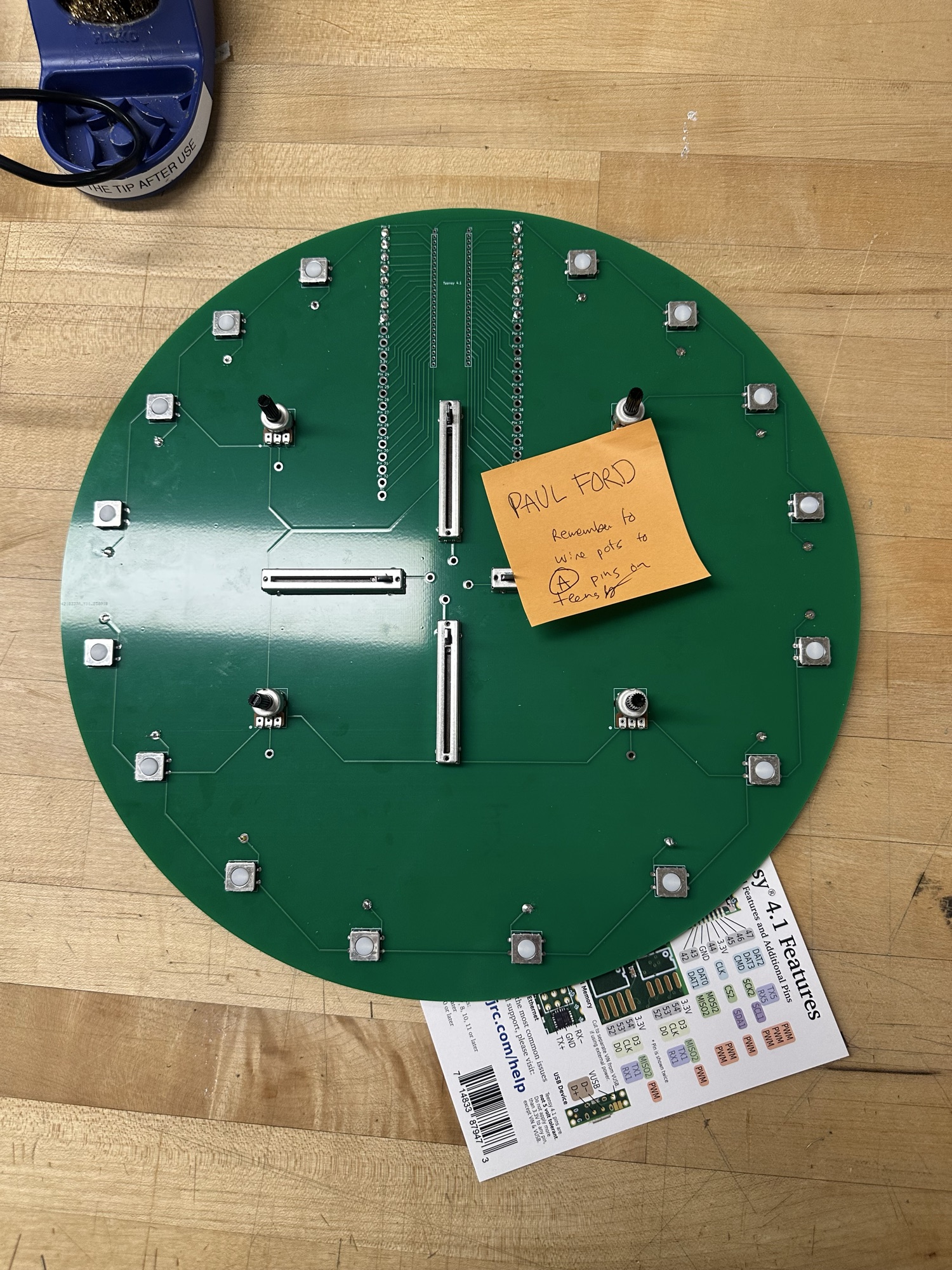 A round PCB with 16 switches four sliders and four knobs. Size of a clock.